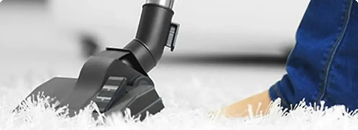 Close-up of a professional vacuuming a white carpet in Solsberry.